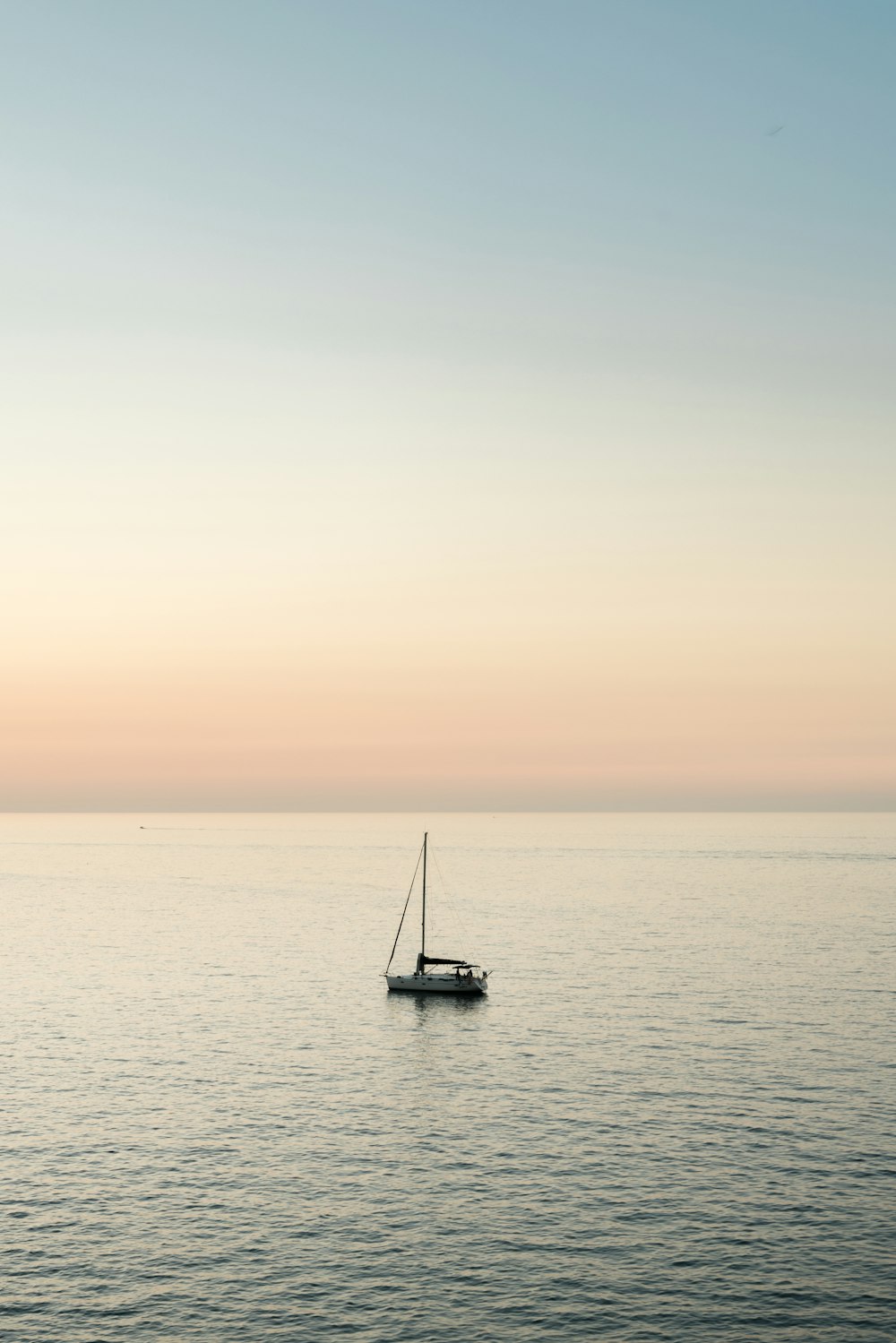 a sailboat floating in the middle of the ocean