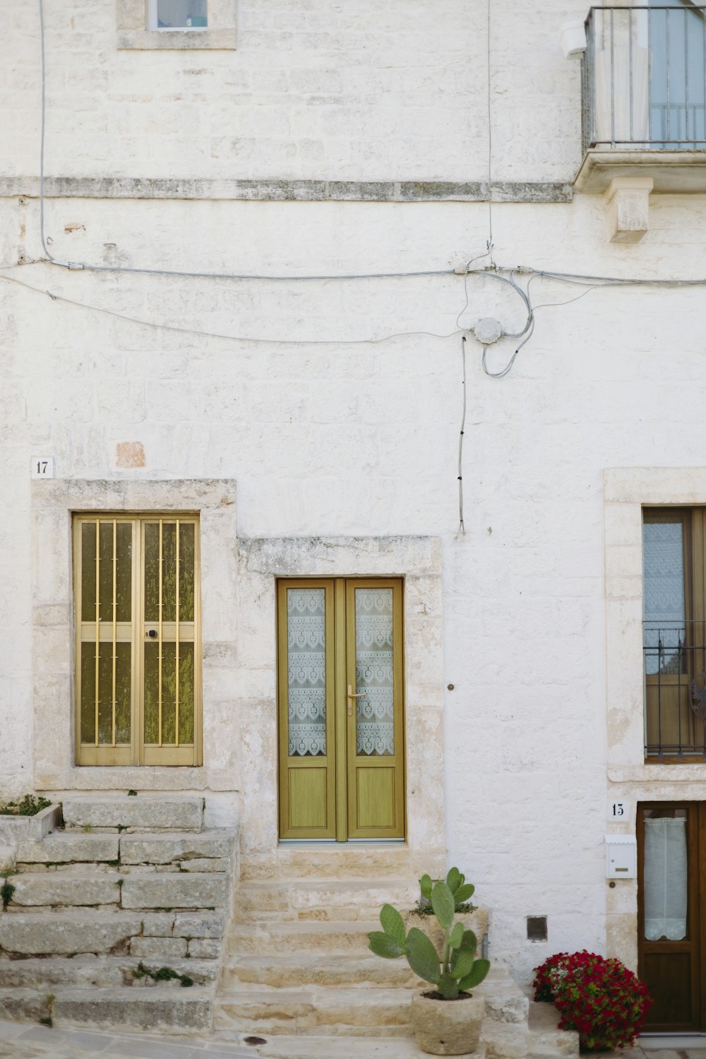 a white building with a green door and steps