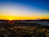 Sunset over a mountainous mining landscape with mining trucks.