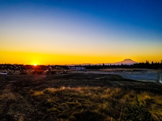 Sunset over a mining site showing trucks and excavators at work.