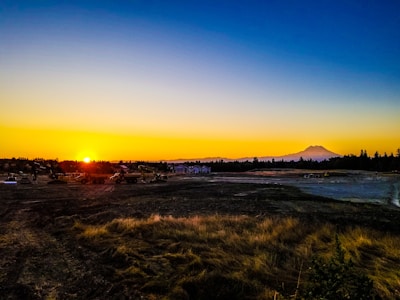Sunset over a recently terraplaned construction site with visible machinery tracks.