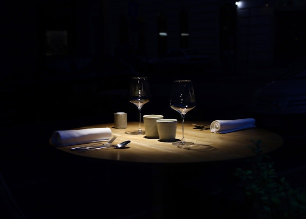 A warmly lit table set for two with a wood-fired pizza and glasses of wine at Roadhouse.