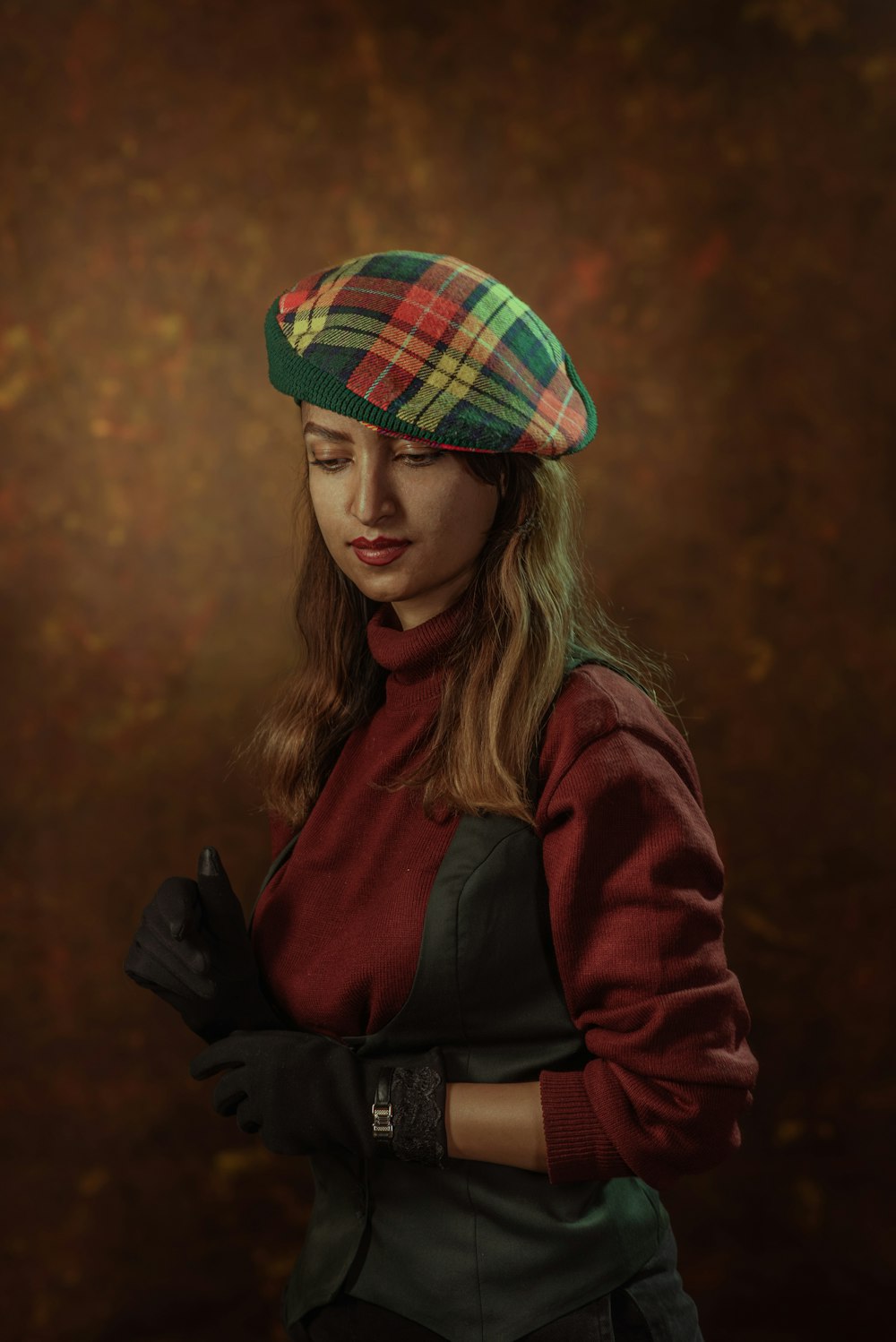 a woman wearing a plaid hat and gloves