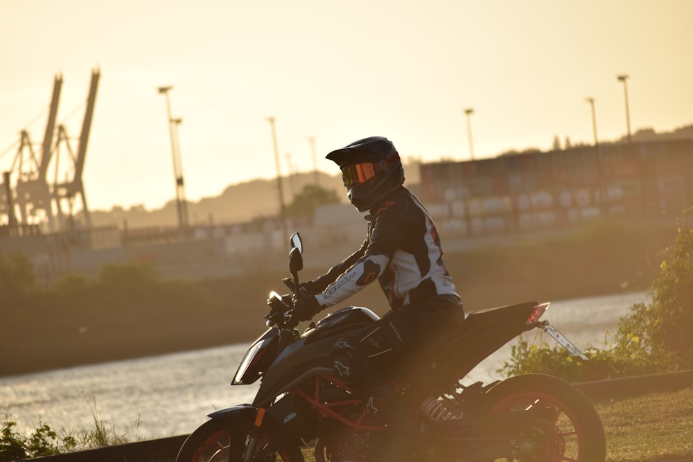 a man riding a motorcycle on top of a lush green field