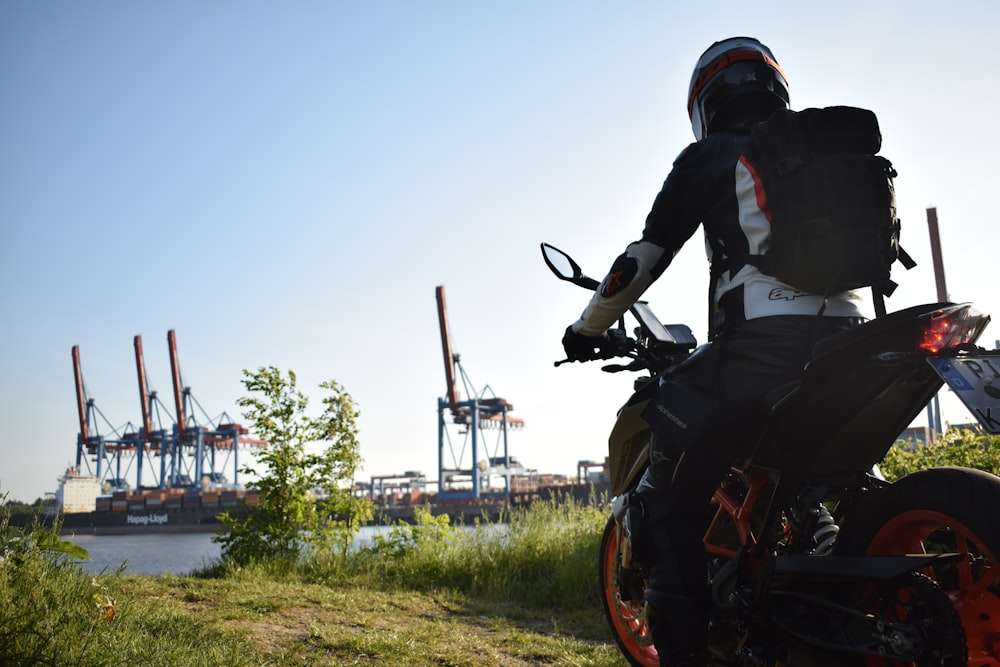 a man riding a motorcycle on top of a lush green field