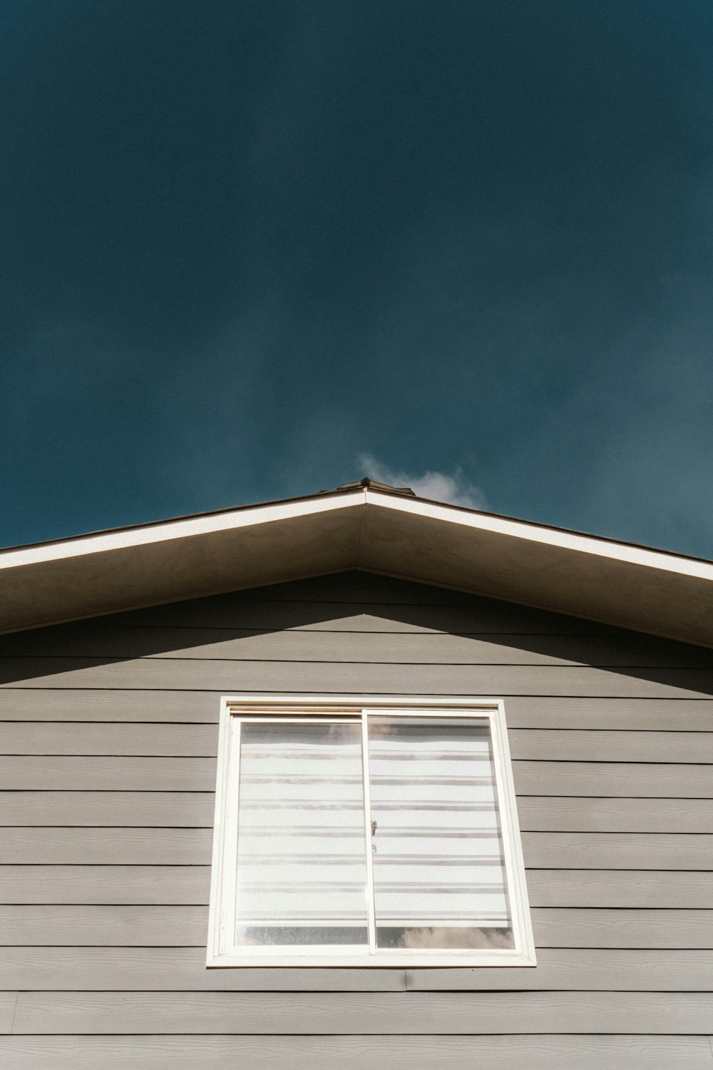 a cat sitting on a window sill in front of a house