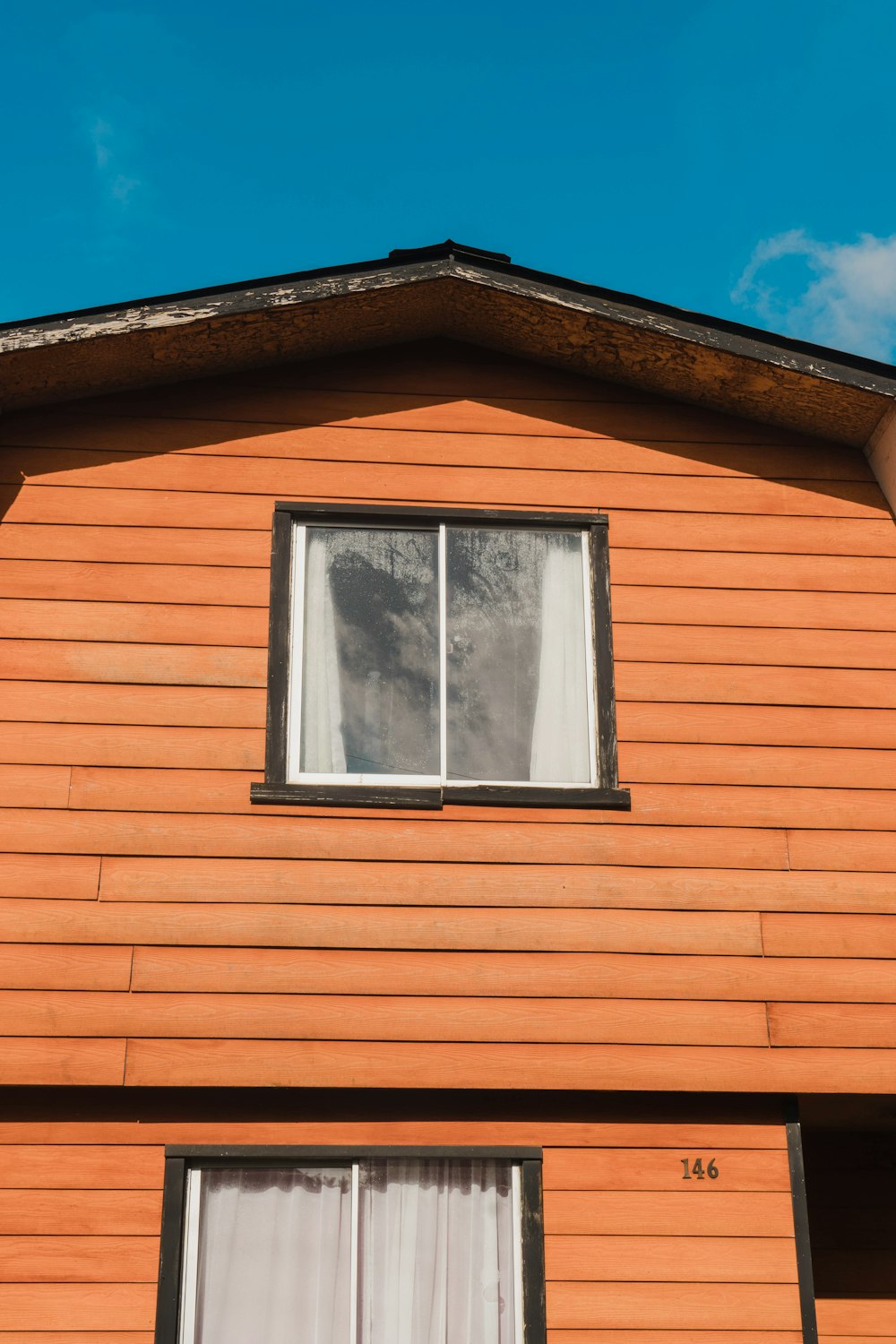 a cat is looking out of the window of a house