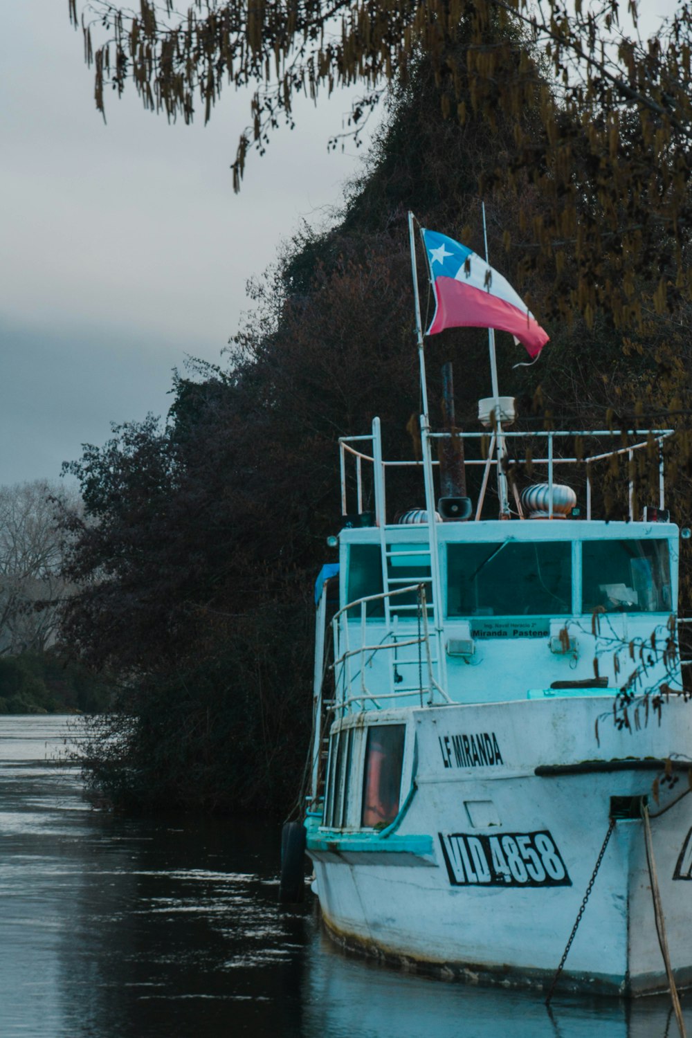 a blue and white boat with a flag on top of it