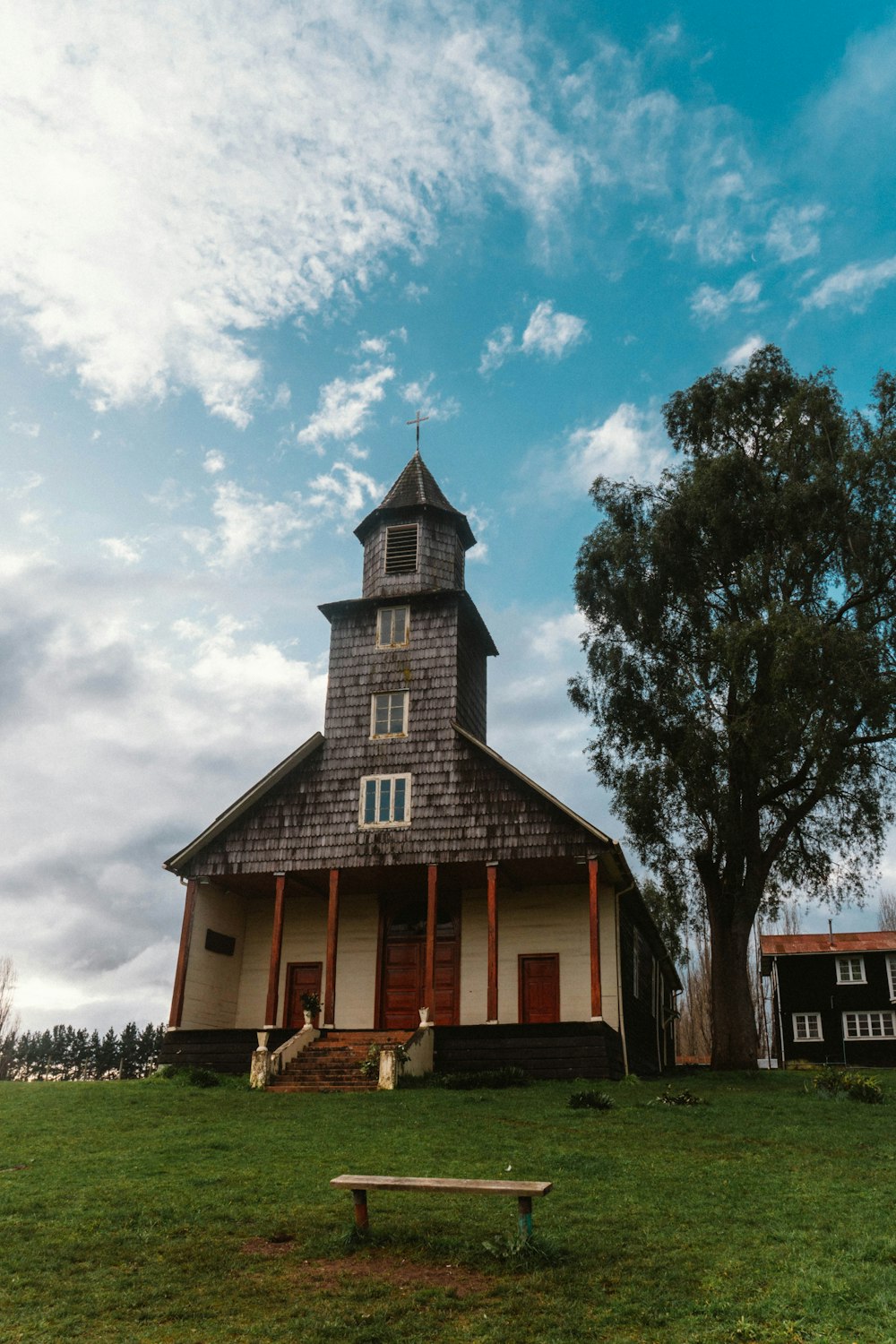 a small church with a bench in front of it