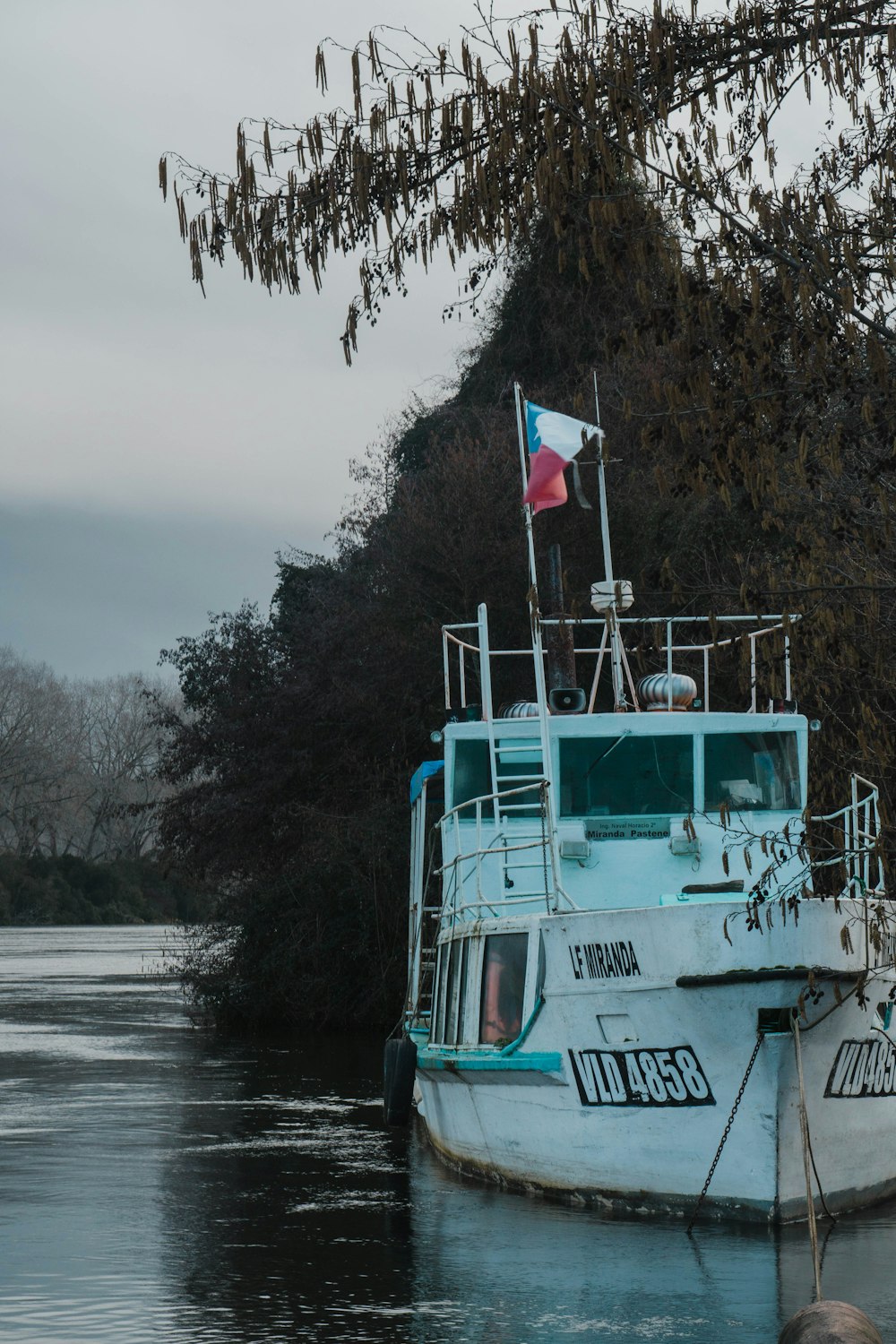 a blue and white boat sitting on top of a body of water