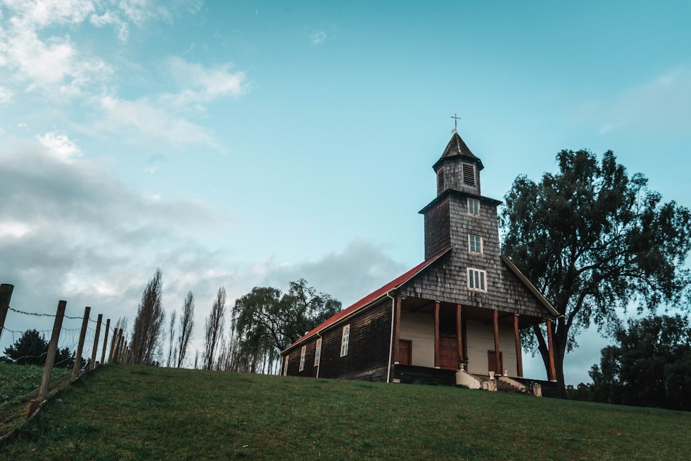 a small church with a steeple on a hill