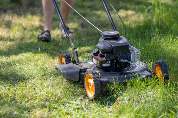 a person mowing the grass with a lawn mower