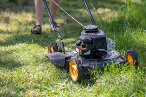 a person mowing the grass with a lawn mower