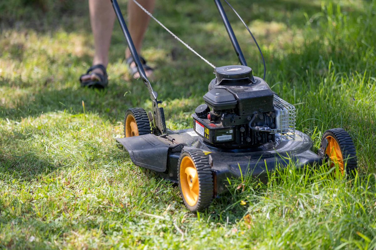 Person mowing a lawn with a lawnmower