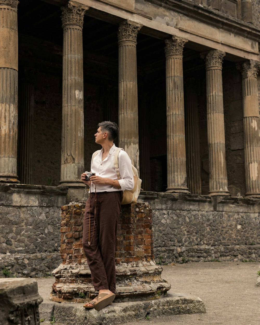 a man standing in front of a stone building