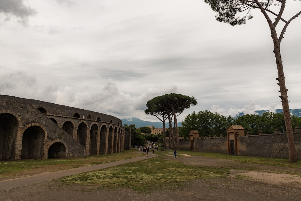 a group of people walking around a stone building