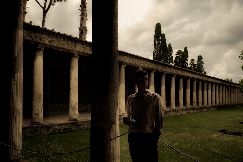 a man standing next to a tall wooden pole