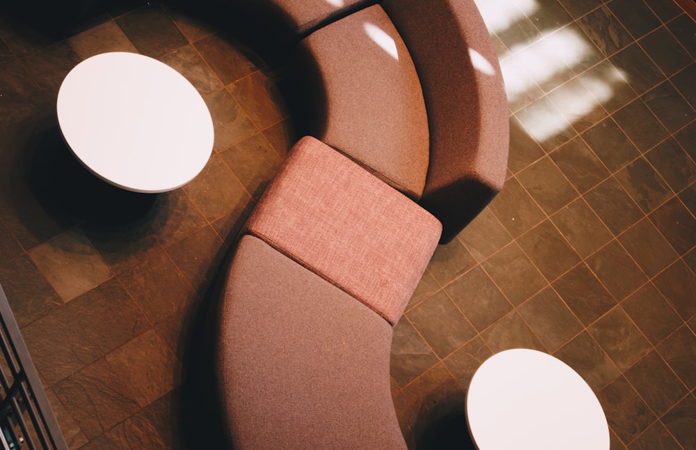 a curved couch sitting on top of a tiled floor