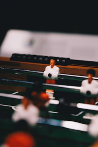 Close-up of hands skillfully maneuvering foosball rods in a competitive match.