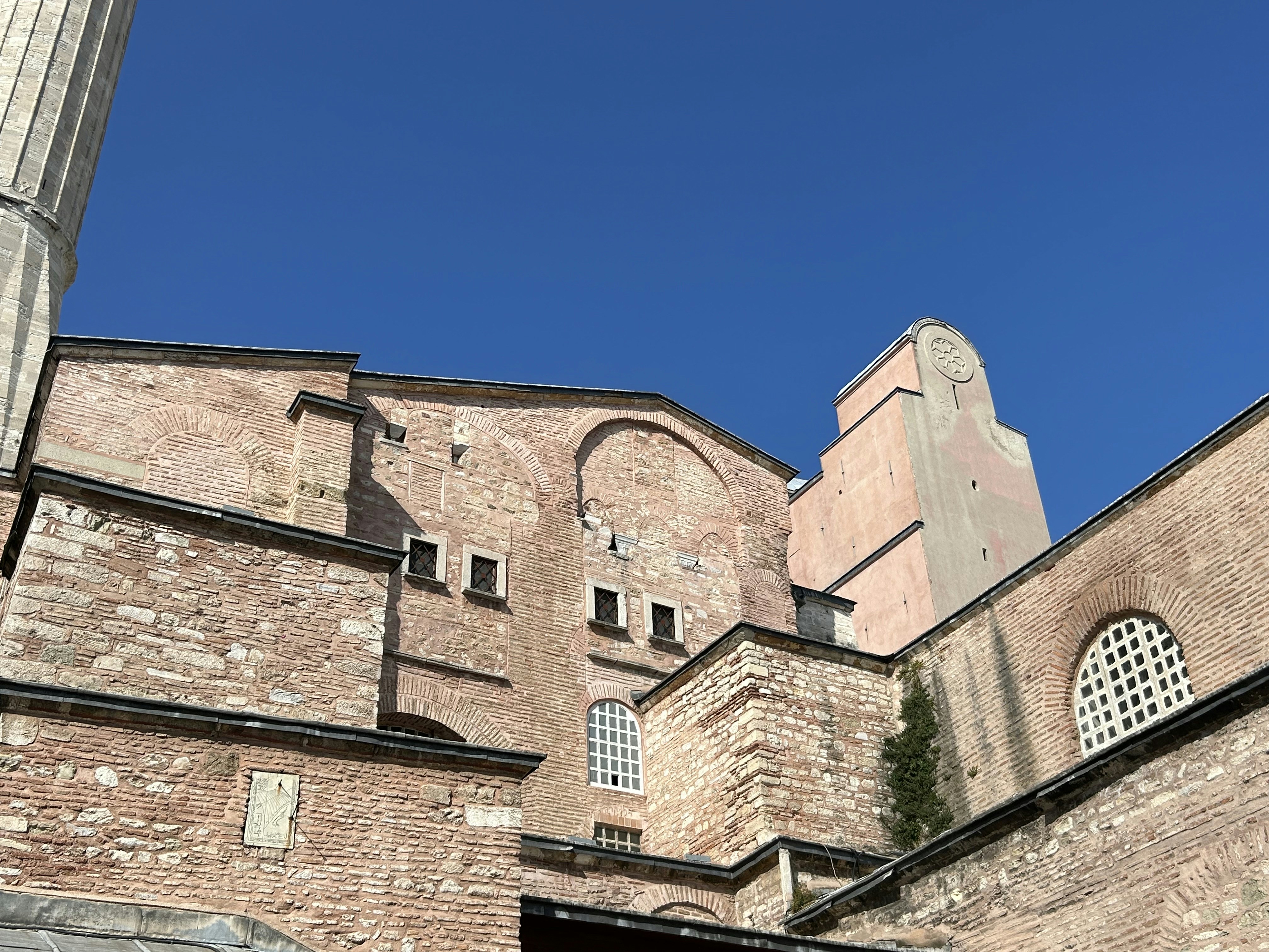 A tall brick building with a clock on it's side