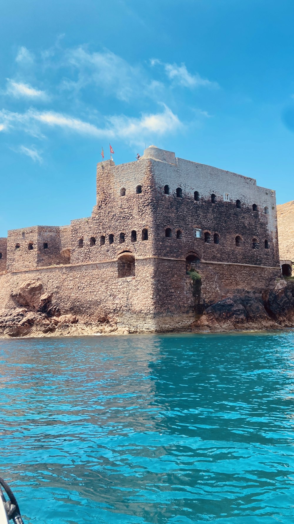 a large castle sitting on top of a cliff next to a body of water