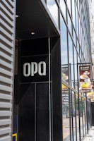 Front view of a modern commercial building facade with sleek ACM panels and illuminated 3D letters.