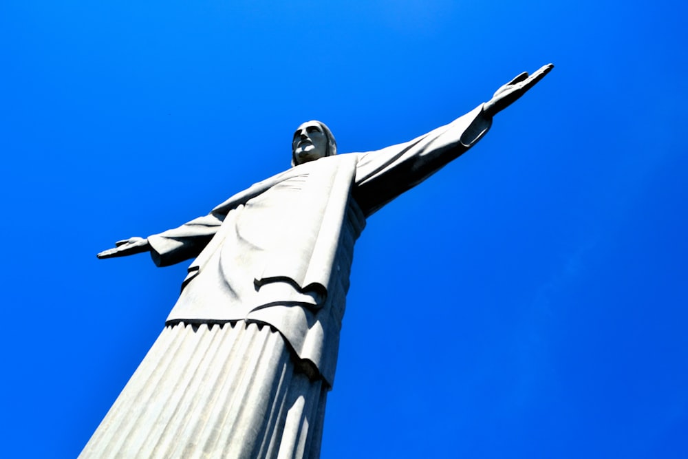 a statue of jesus is shown against a blue sky