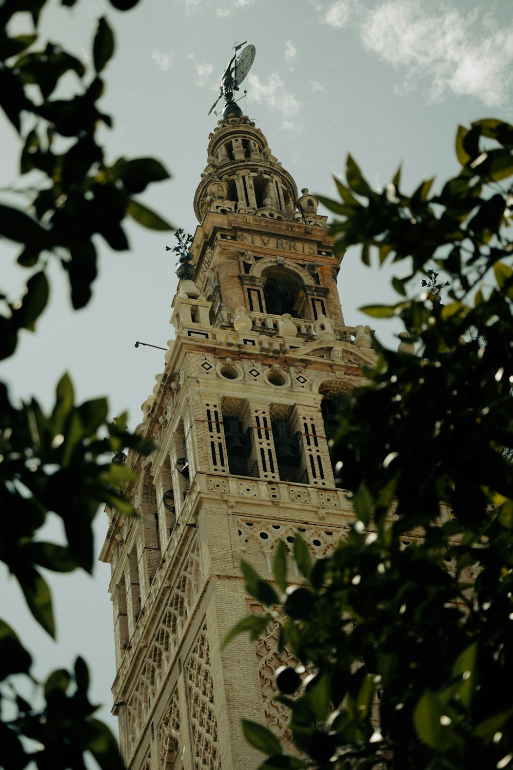 a tall clock tower with a weather vane on top