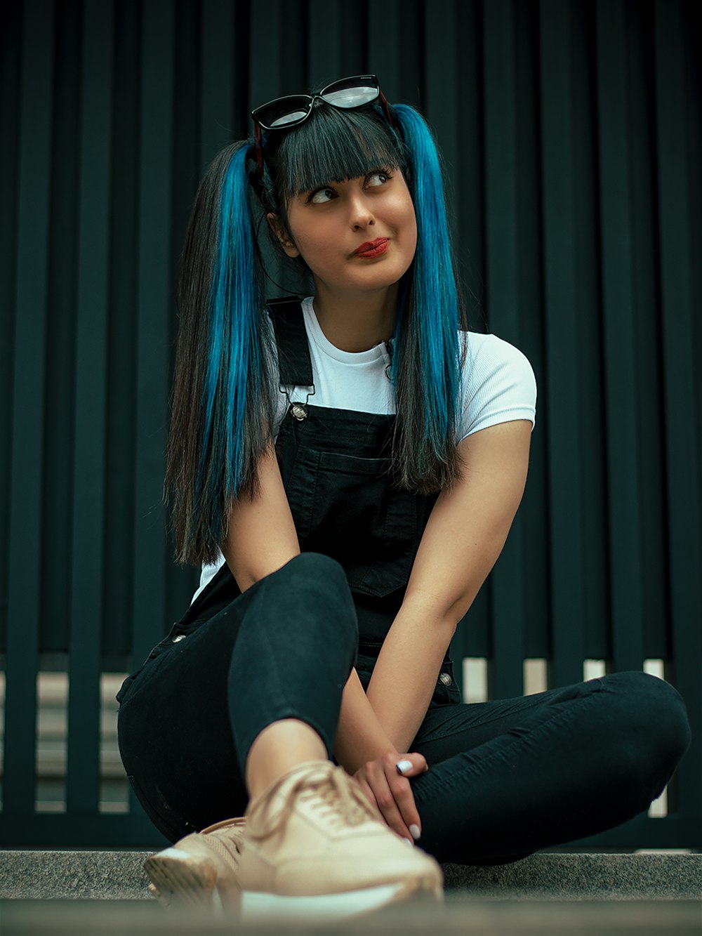 a woman with blue hair sitting on the ground