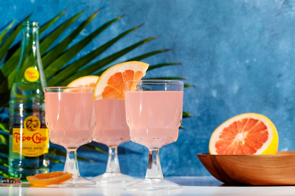 a table topped with three glasses filled with liquid