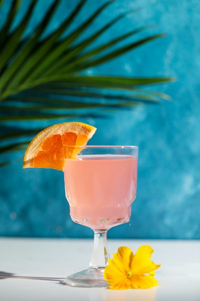 A tropical punch drink in a glass with an orange slice garnish on a sunny background
