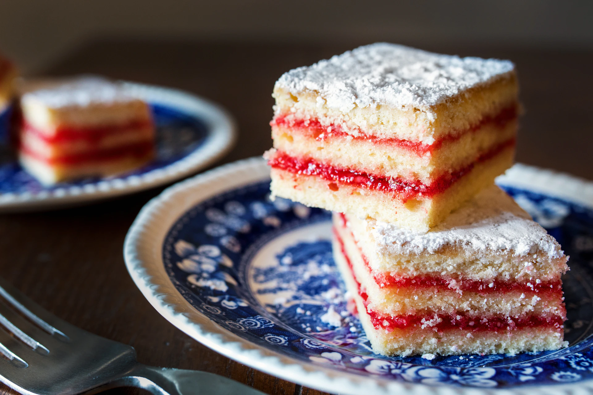 three pieces of cake on a blue and white plate