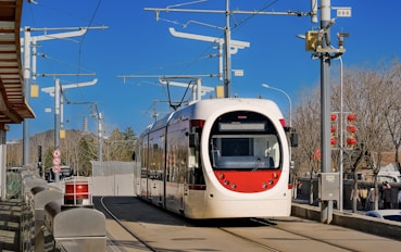 a red and white train traveling down train tracks