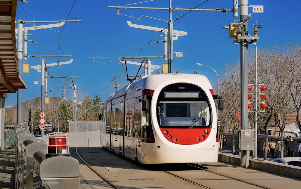 a red and white train traveling down train tracks