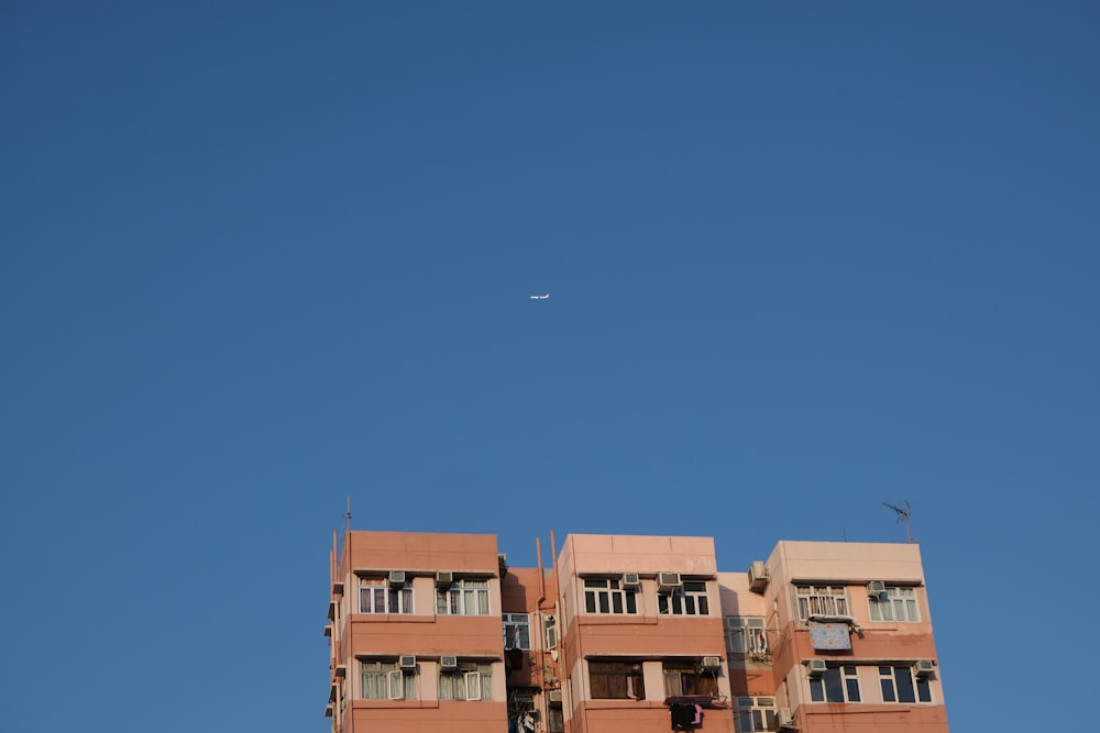 an airplane flying over a building with balconies