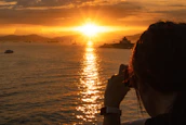 A vibrant travel influencer capturing a sunset on a tropical beach.