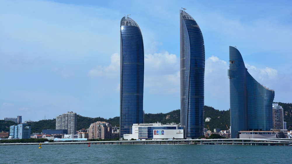 a couple of tall buildings sitting in the middle of a body of water