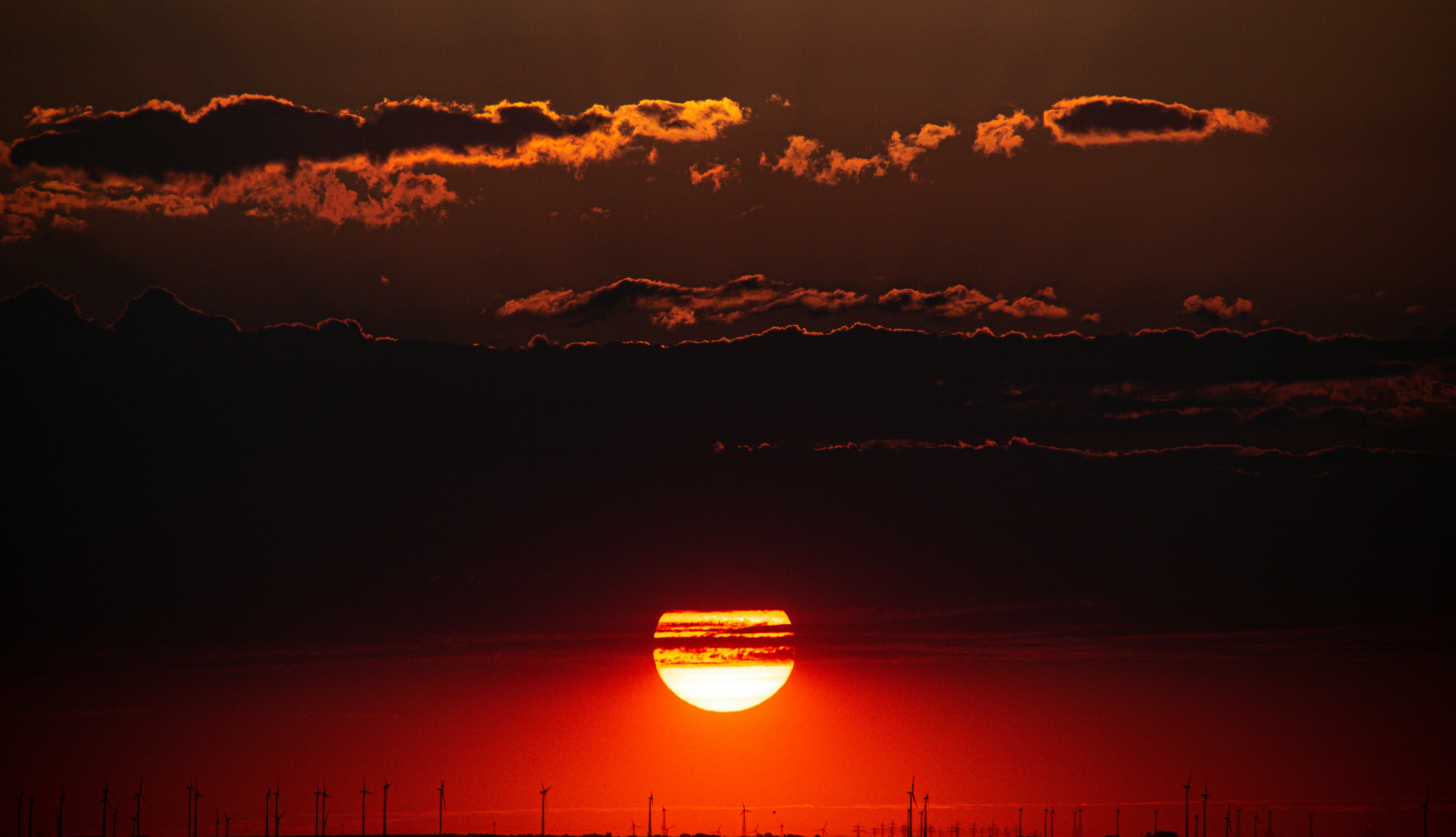 the sun is setting over a large field