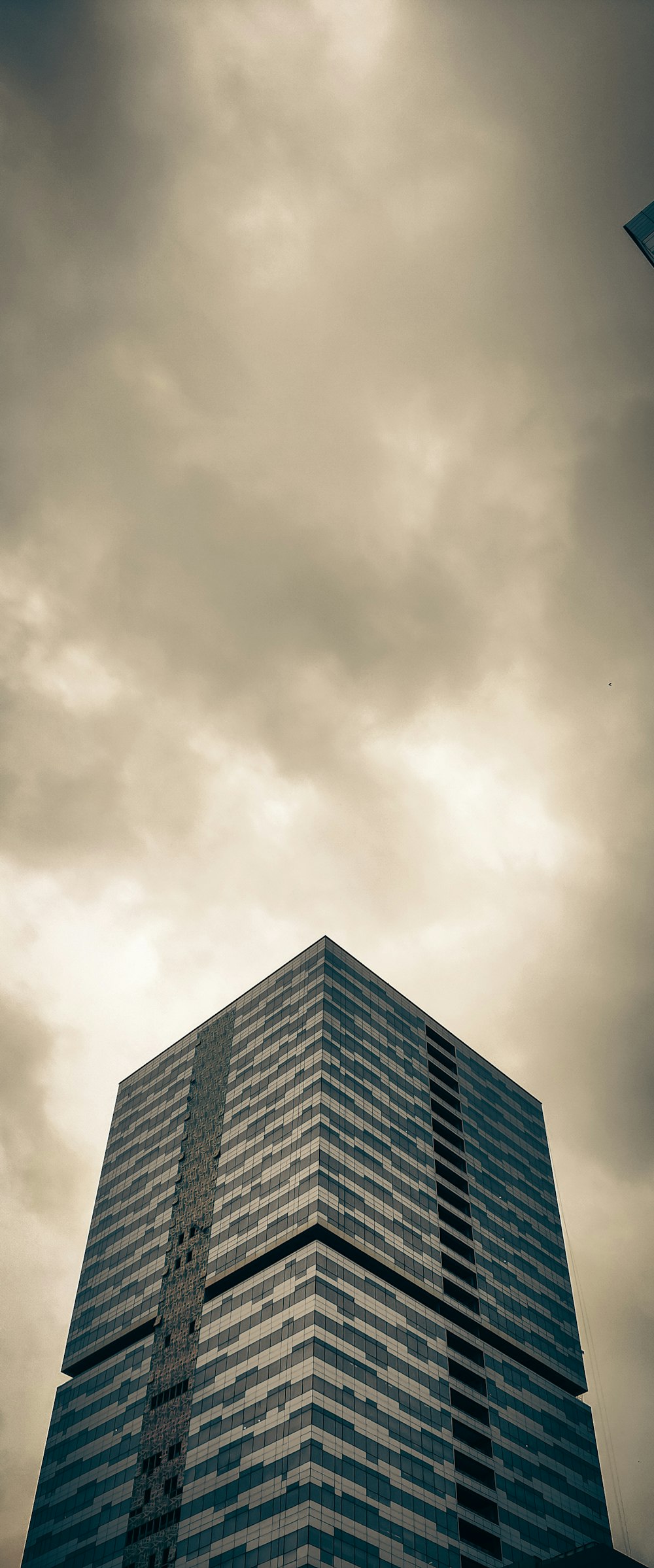 a tall building sitting under a cloudy sky