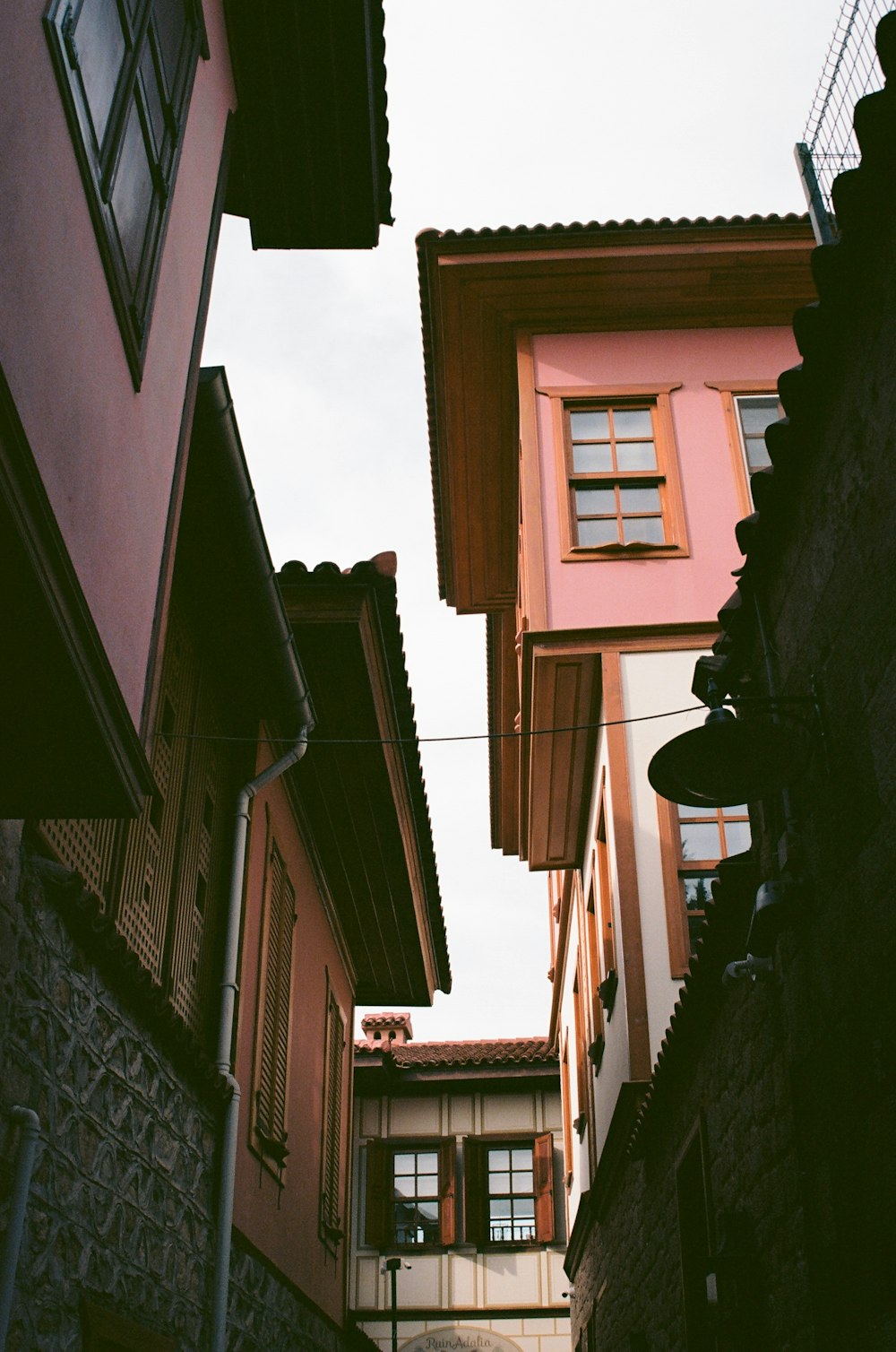 a narrow alleyway between two buildings with windows