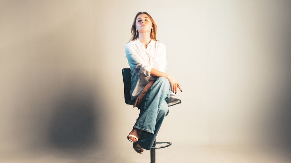 a woman sitting on top of a stool