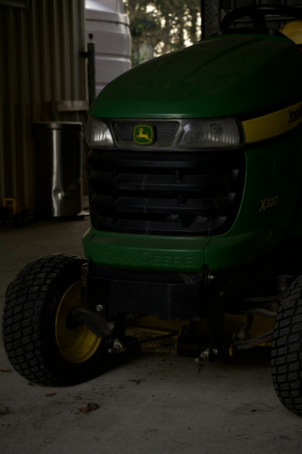 a green tractor parked inside of a garage
