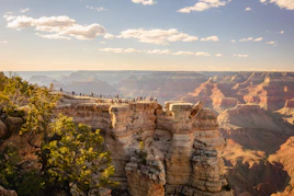 a group of people standing on the edge of a cliff