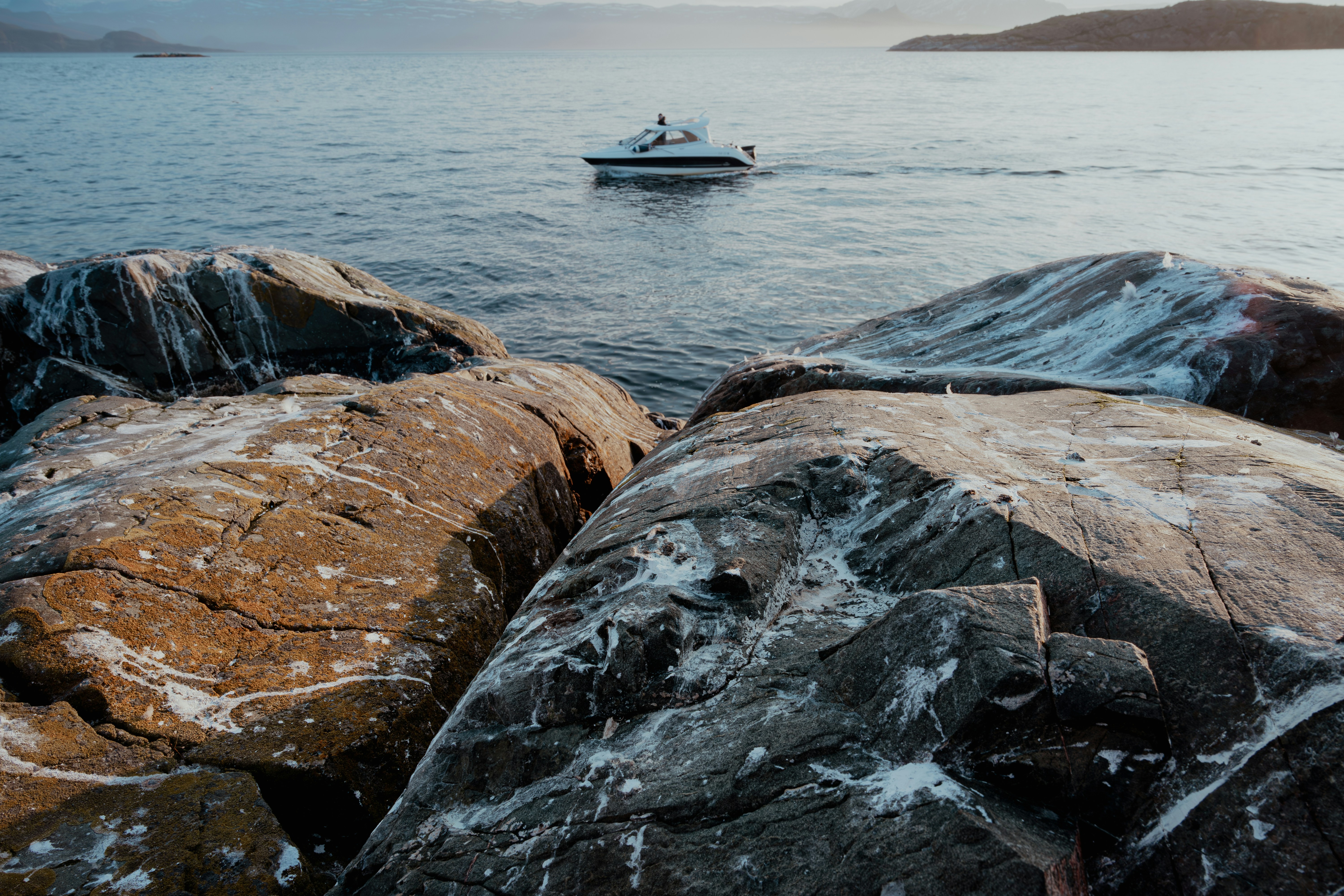 a boat in the water near some rocks