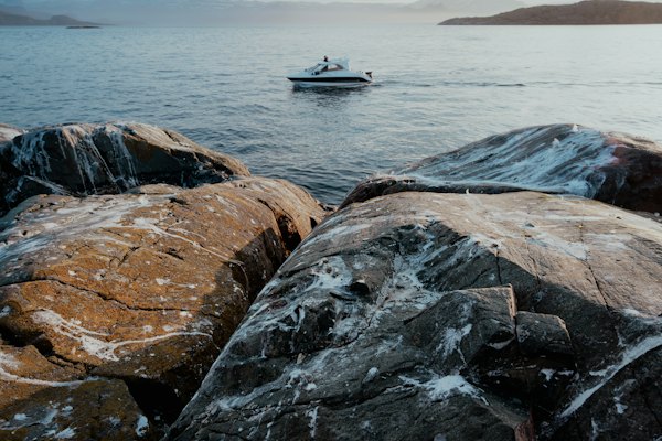 A boat off the rocky shore of the fjord — Alta, Norway