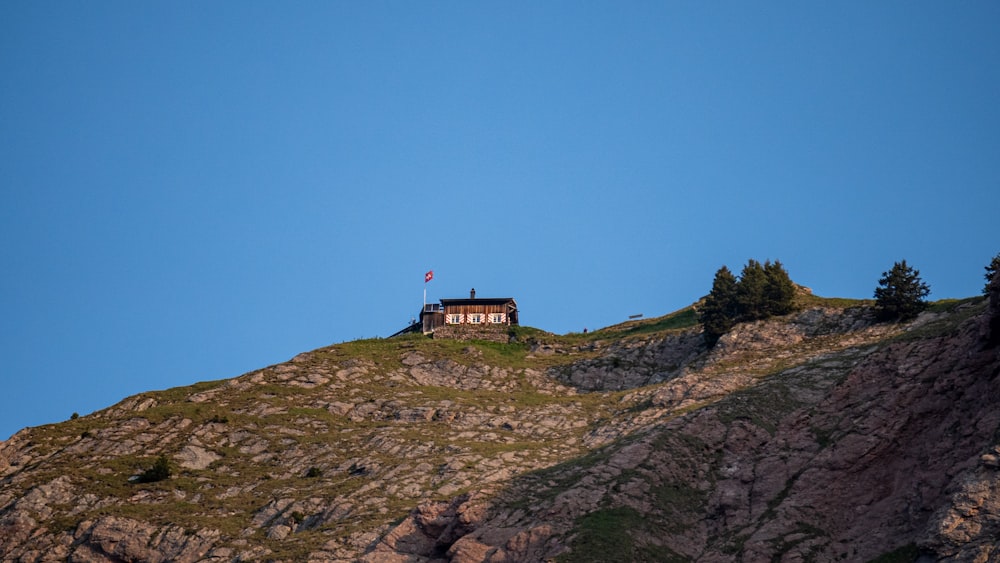 Une maison au sommet d’une montagne avec un ciel bleu