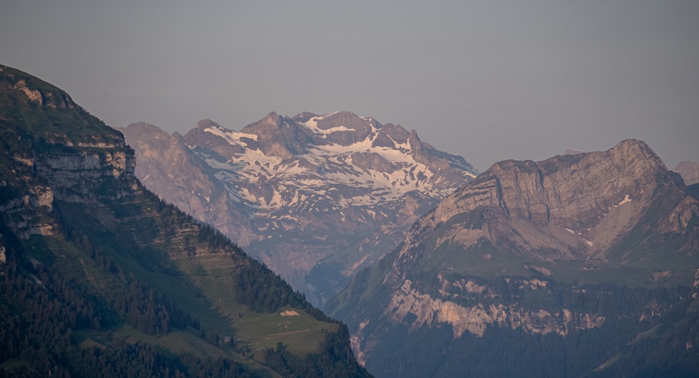 a mountain range with snow capped mountains in the distance