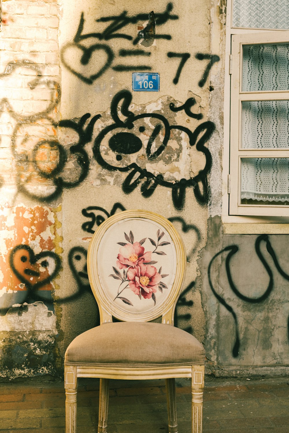 a chair sitting in front of a wall covered in graffiti