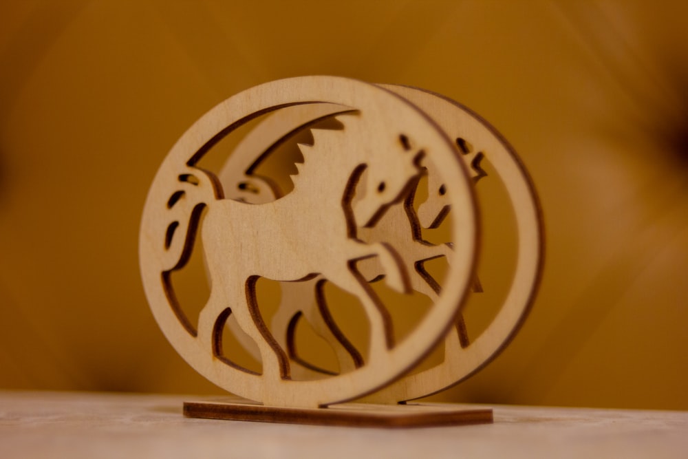 a wooden ornament with two horses in a circle