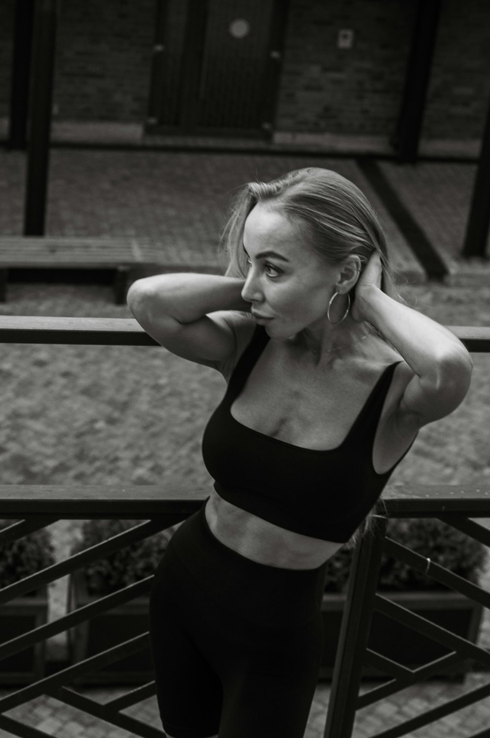 a black and white photo of a woman leaning on a rail